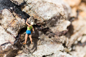 Obraz premium Miniature people : Women are playing high climbing sport. Used as a background for holiday adventure travel business concept.