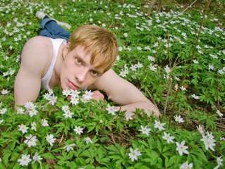 guy in the tank top laying in the green grass