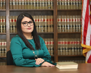 Young attractive hispanic woman, women attorney in law library, portrait of an immigration lawyer
