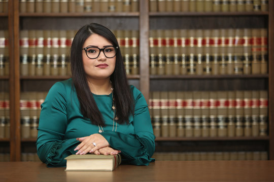 Portrait of a young attractive hispanic woman, women attorney in law library