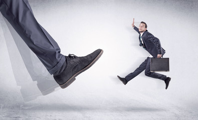 Black shoe kicking small man