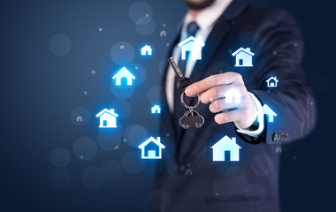 Businessman holding keys with houses around