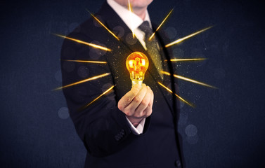 business person holding an electric light bulb
