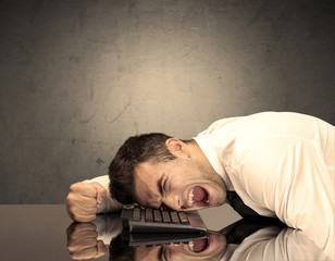 Obraz premium Frustrated businessman's head on keyboard