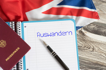 Deutscher Reisepass, Flagge von Großbritannien und ein Heft mit dem Wort Auswandern
