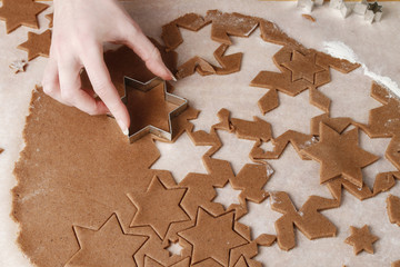 Woman making gingerbread cookies in star shape.