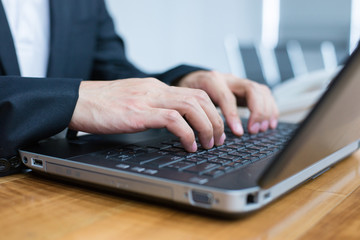 close up hand of businessman typing keyboard on laptop. business people and technology concept.