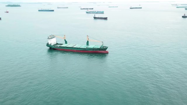 Singapore. December 04, 2017: Beautiful aerial footage of cargo ships at Singapore strait, waiting for entering one of the busiest ports in the world. Shot in 4k resolution