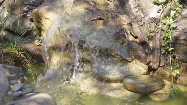Small cascade waterfall in artificial pond