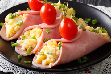 Ham roll with scrambled eggs and tomatoes close-up. horizontal