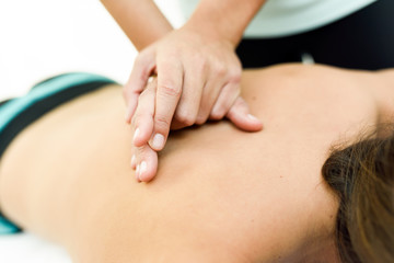Obraz na płótnie Canvas Young woman receiving a back massage in a spa center.