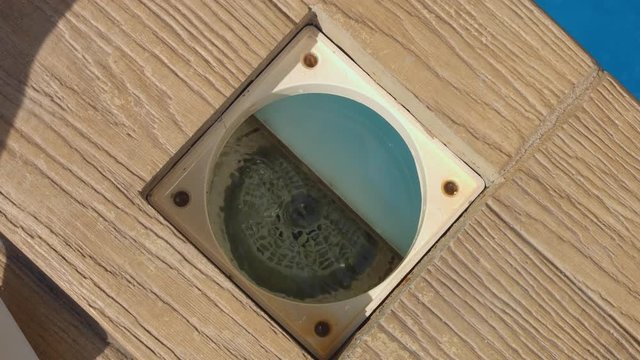 Pouring chlorine tabs in swimming pool skimmer