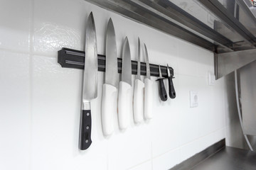 Knives on  magnetic wall support in a kitchen