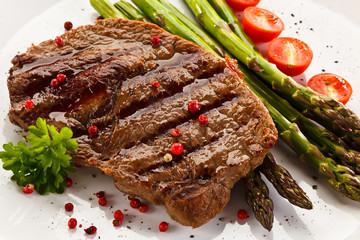 Grilled steak with asparagus on white background