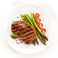 Grilled steak with asparagus on white background