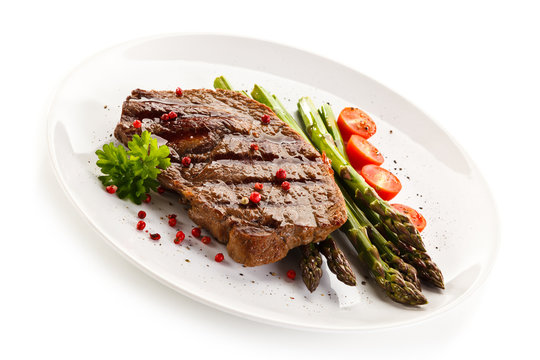 Grilled steak with asparagus on white background
