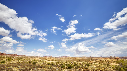 Vast deserted landscape with beautiful cloudscape on the blue sky.