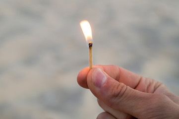 Burning match in right hand