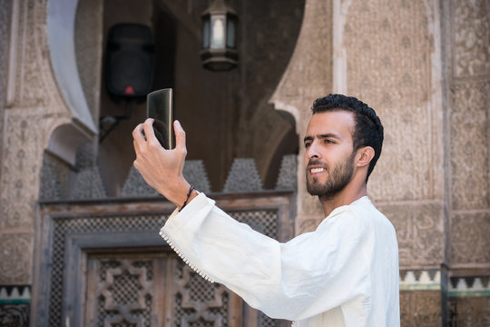 Arab man in traditional clothing taking selfie