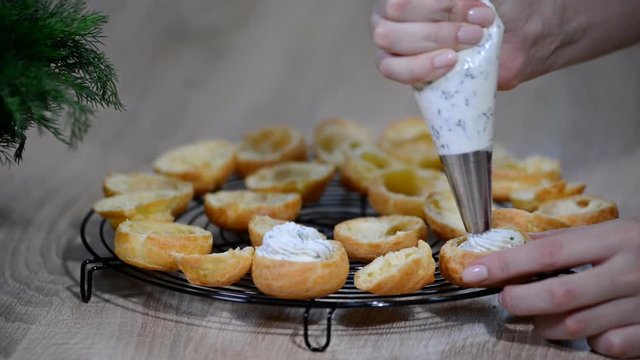 The chef fills the profiteroles cream