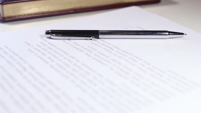 Pen with document on white table.