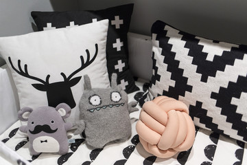 Modern design plush toys on a bed with black and white pillows