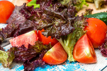 Tomatoes,lettuce, cucumbers on the old wooden table.