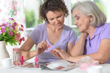 daughter  making manicure to mother 