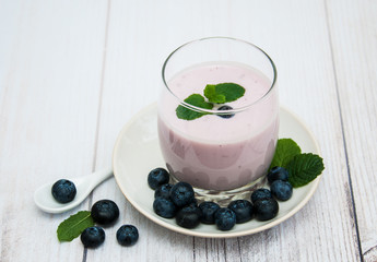 Glass with blueberry yogurt on a table