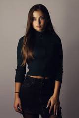 fashion beautiful young woman posing on a gray background 