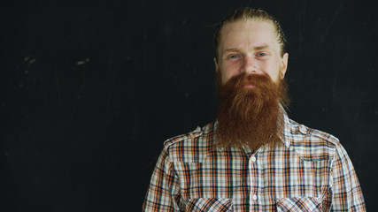 Closeup portrait of hipster man looking at camera and smiling on black background
