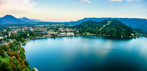 Fototapeta na wymiar Evening views on the lake Bled with the famous Pilgrimage Church of the Assumption of Maria and Bled Castle and Julian Alps at background