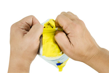 Hand trying to unwrap a pastry bag Represents the gesture during a tear the bag out using two hands to pull it out to eat the candy inside.  ( clipping path )