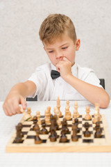 boy pondered before making a move, playing chess