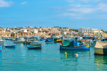 panoramic aerial skyline view to european harbor with village Marsaxlokk and traditional colorful Luzzu fishing boats, Malta