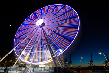 GENOA, ITALY, NOVEMBER 27, 2017 - Ferris wheel with colored lights in "Porto Antico" harbor zone in Genoa, Italy