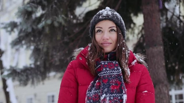 Portrait young beautiful woman standing on the street falls snow smiles christmas snowball winter young beautiful girl happiness joy outdoor throwing white hat fun happy holiday park play attractive