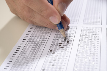 Student filling out answers to a test with pencil close up. 