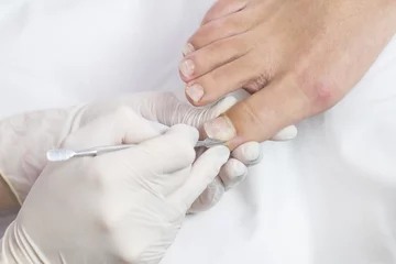 Foto op Plexiglas Female foot in the process of pedicure procedure in a beauty salon close-up. © lester120