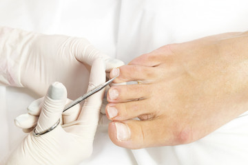 Female foot in the process of pedicure procedure in a beauty salon close-up.