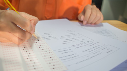 Students hands taking exams, writing examination room with holding pencil on optical form of...
