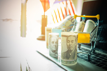 American dollars, JPY, Euro money in trolley on laptop keyboard. Idea of exchange money online shopping, Online shopping is form of e-commerce, consumers to buy goods from  seller through internet.