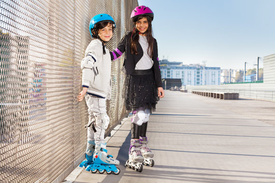 Boy and girl rollerblading at sunny summer day