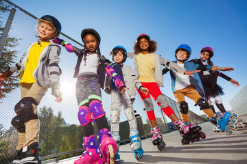 Happy kids rollerblading with hands like wings © Sergey Novikov