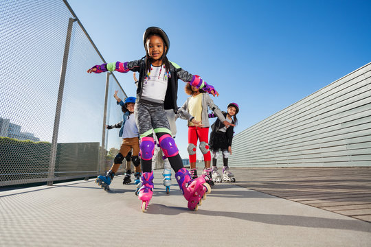 African girl rollerblading with hands like wings