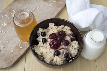 Delicious oatmeal porridge with berry and almonds for breakfast.