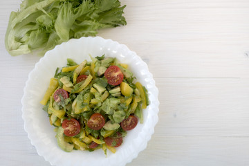 Appetizing vegetable salad consisting of tomatoes, avocado, yellow sweet pepper, lettuce and seasonings. Space for copy space.