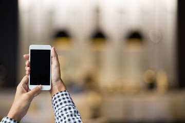 The man holding smart phone at coffee shop.