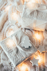 Fototapeta na wymiar Winter holiday Christmas decorations, white gift boxes and knitt