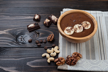 Fototapeta premium Homemade chocolate banana smoothie on a bowl on wooden background